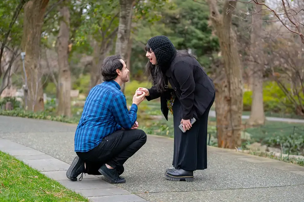a man on his knee proposing to his future wife.